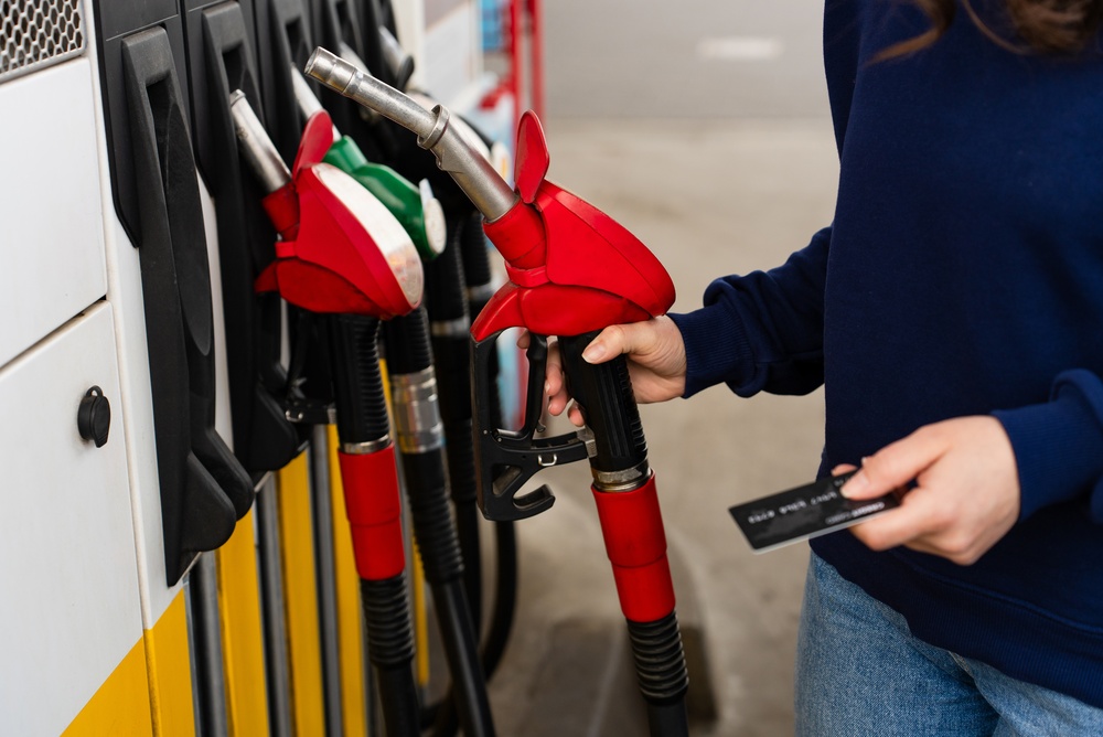 Credit card held near petrol pump during car refueling