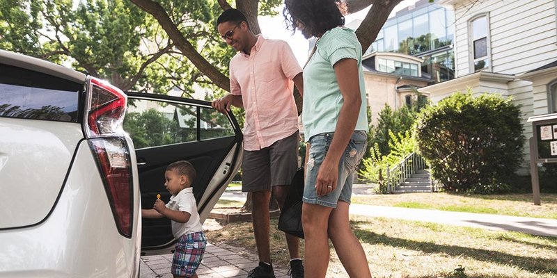 Young parents and their toddler son get ready to load into the car
